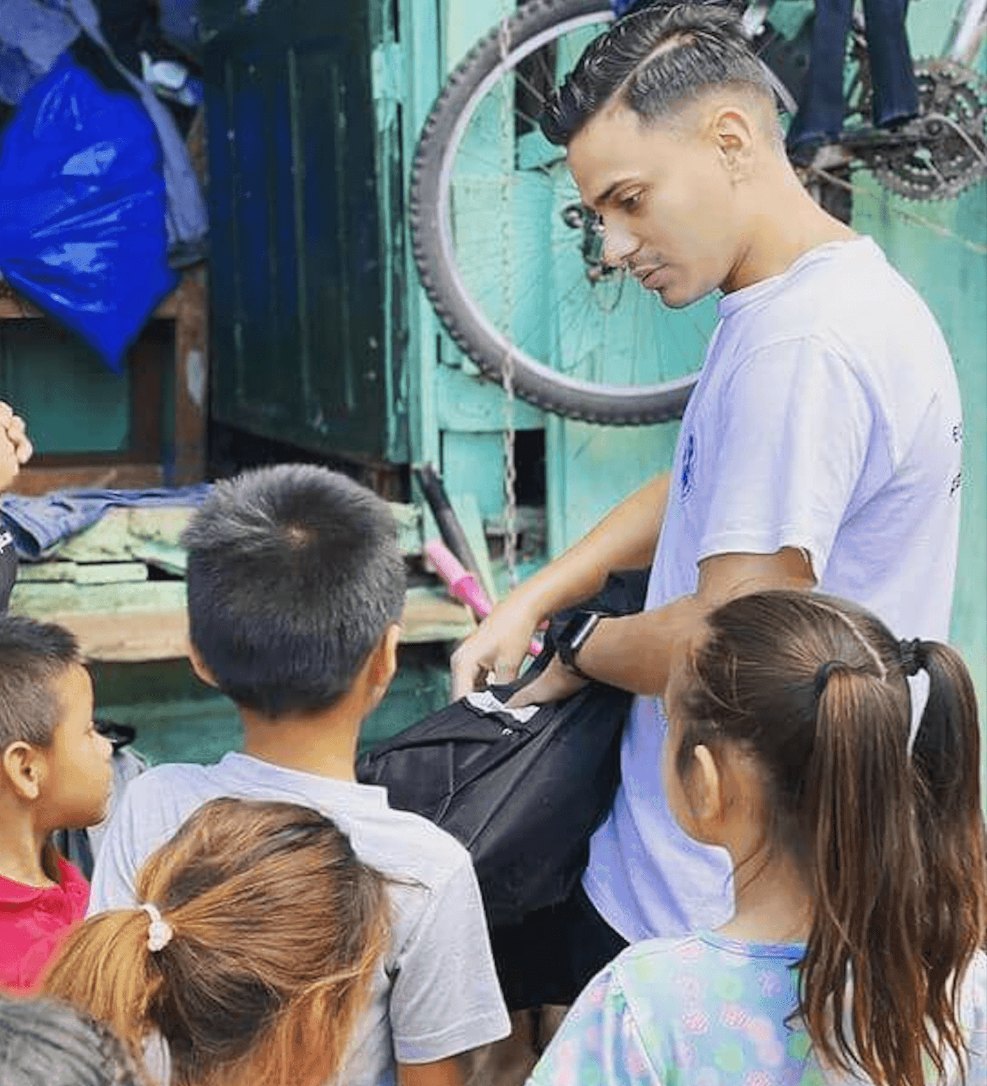 Voluntario trabajando rodeado de niños y niñas.